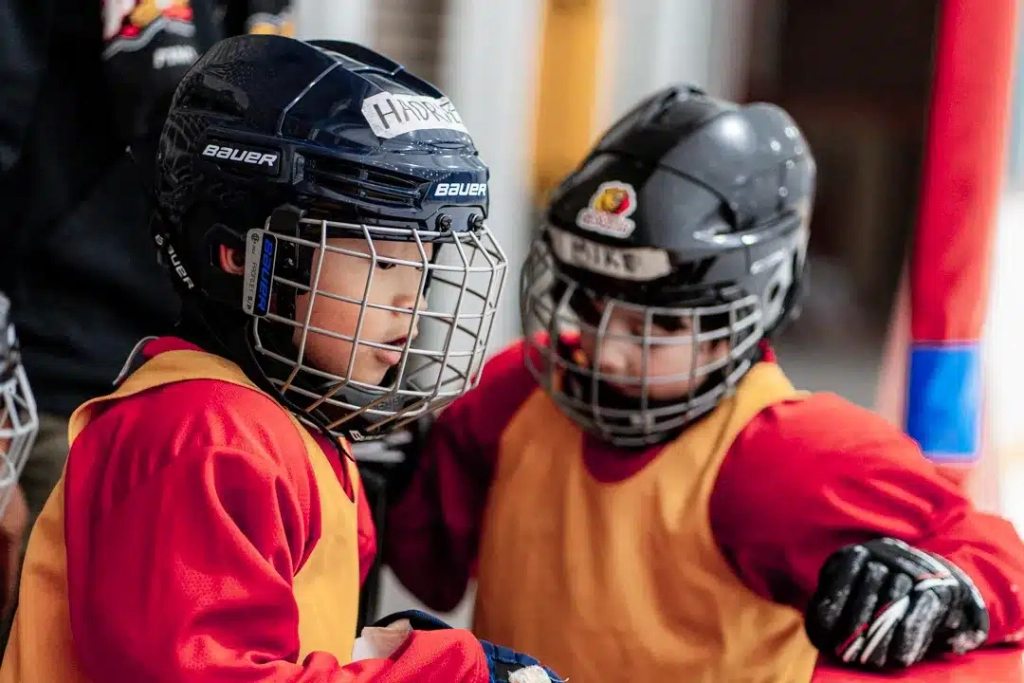 Un jeune joueur de Hockey asiatique et son ami aux Jeux du Sud-Ouest par Studios Machiavel