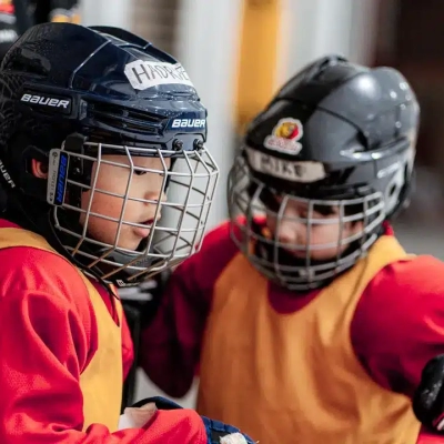 Un jeune joueur de Hockey asiatique et son ami aux Jeux du Sud-Ouest par Studios Machiavel