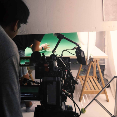 Behind the scenes of shooting video or movie production crew team and silhouette of camera and equipment in studio.